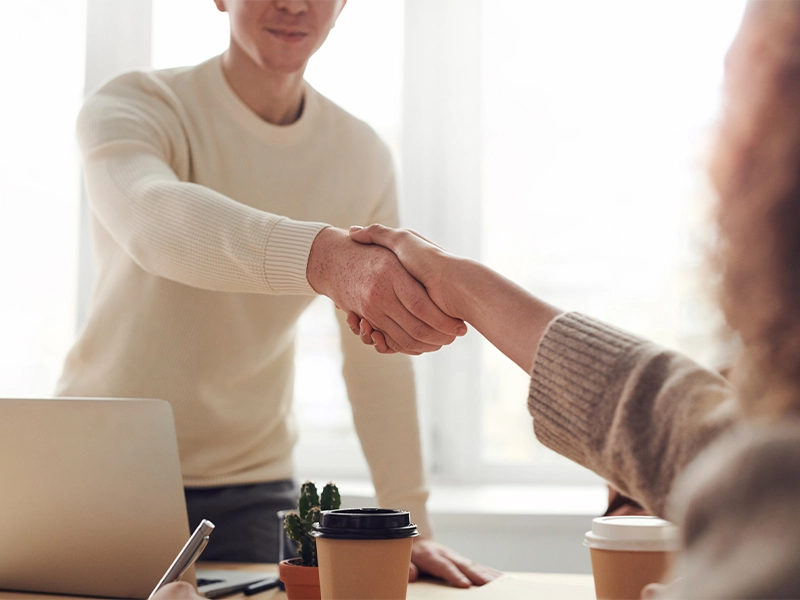 Man and Woman Shaking Hands Near Table