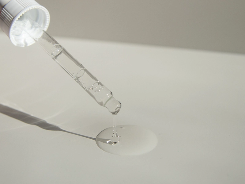 Anonymous Person Pouring Liquid Product On Table With Pipette